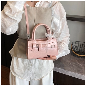 Dettaglio della borsa in pelle rosa con fiocco chic ed elegante ciondolo in pizzo