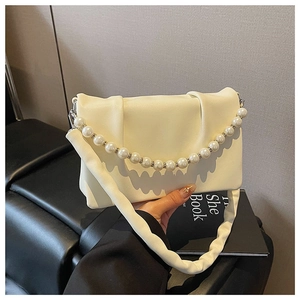 Détail du sac plissé en cuir crème avec chaîne de perles et bandoulière souple en cuir
