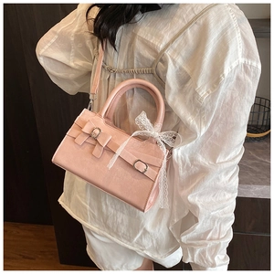 Borsa a mano rosa in ecopelle con fiocco e nastro in pizzo bianco sulla spalla
