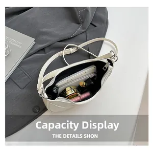 Vue intérieure du sac demi-lune blanc cassé avec téléphone et cosmétiques