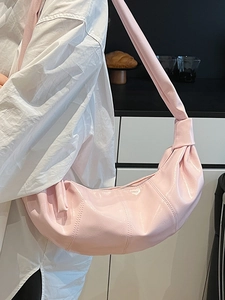 Minimalist pink faux leather dumpling shoulder bag with glossy finish and knot detail