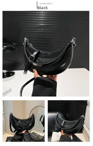 Vue détaillée du sac demi-lune noir avec finition brillante et boucle en métal argenté