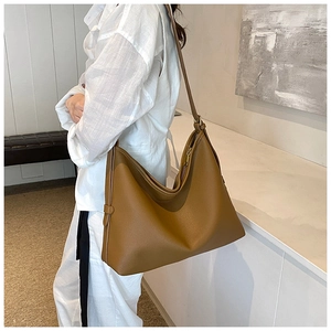 Fashionable caramel oversized tote bag in grainy faux leather shown in a lifestyle setting