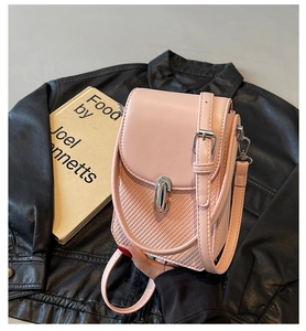 Detailed close-up of pink leather shoulder bag with woven texture and silver buckle