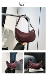 Trois vues du sac en cuir croissant rouge bordeaux avec poignée et finitions argentées