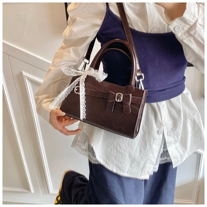 Dettaglio della borsa vintage marrone scuro con fiocco in pizzo e fibbia in pelle