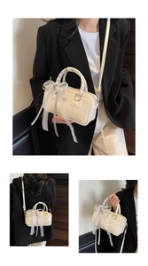 Detail of cream white mini Boston bag featuring delicate lace ribbons and bow embroidery