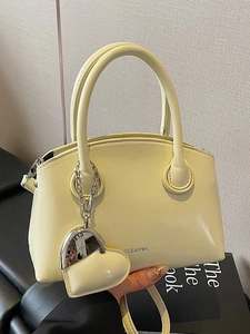 Minimalist light yellow crossbody handbag with heart charm and adjustable shoulder strap