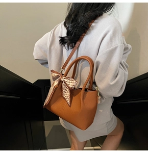 Détail du sac cabas marron en cuir avec foulard en soie et bandoulière longue