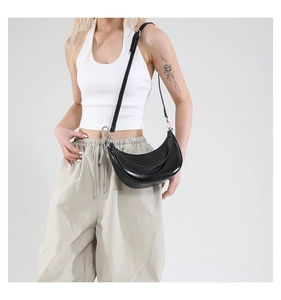 Vue détaillée du sac croissant noir avec finition cirée lisse et boucle argentée
