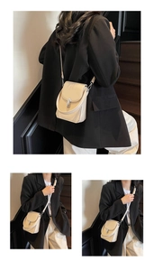 Close-up of cream textured flap bag with silver twist lock and woven detailing