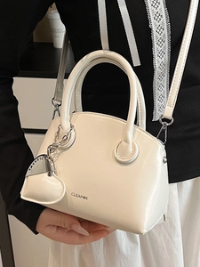 Minimalist white patent leather mini handbag with heart charm and crossbody strap