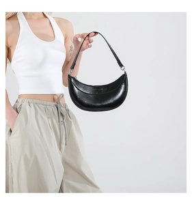 Détail du sac demi-lune noir en cuir ciré vintage avec des détails de texture plissés