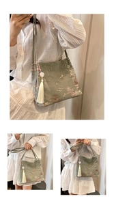 Détail d'un sac vert sauge de style chinois avec broderie de montagne et pompon en jade