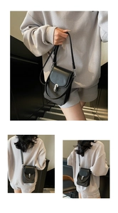 Detail of crossbody phone bag with silver U-shaped buckle and houndstooth fabric texture