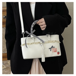 Detail of white PU handbag with lace trim, plaid bow, and strawberry rabbit embroidery