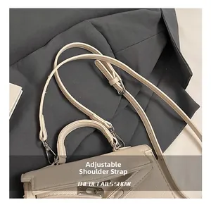 Detail of adjustable shoulder strap and silver buckle on beige quilted pillow bag