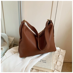 Detail of brown litchi pattern leather Hobo bag with golden metal buckle and strap