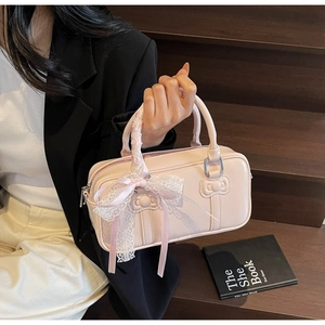 Detail of light pink patent leather bowling bag with bow and lace ribbon handles