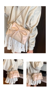 Detail of champagne pearl crossbody bag with oversized bow and silver chain strap