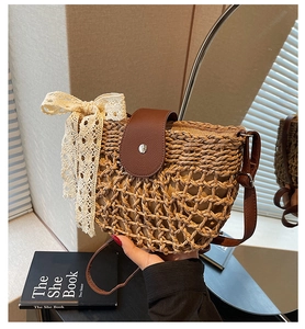 Detail der handgefertigten Strohtasche mit Lederklappe und cremefarbener Spitzenschleife