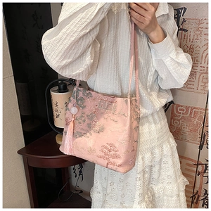 Gros plan d'un sac cabas en jacquard rose avec broderie chinoise traditionnelle et pompon