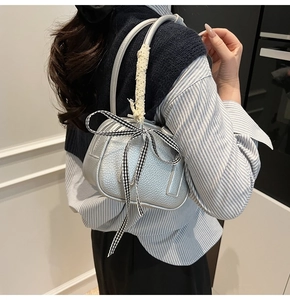 Silver lychee leather handbag featuring a checkered bow and delicate lace handle detail