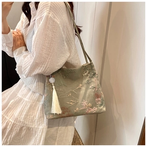 Detail of elegant Chinese style tote bag with mountain embroidery and white silk tassel