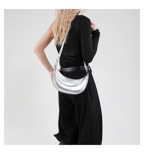 Sac demi-lune argenté en similicuir métallisé porté par un mannequin pour style chic