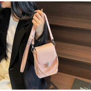 Detail of pink crossbody phone bag with woven texture and silver twist lock on side