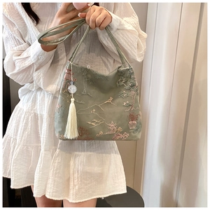 Detailed embroidery of Chinese landscape on large green tote bag with white tassel decor