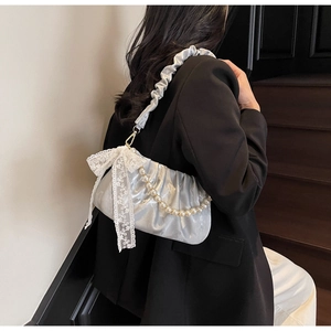 Detail of silver pleated satin shoulder bag with lace bow and pearl chain decoration