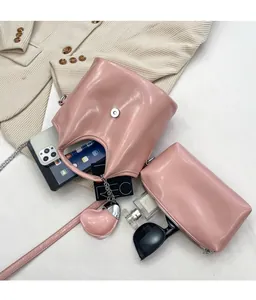 Sac seau en cuir rose montrant sa grande capacité avec pochette et chaîne