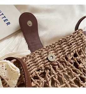 Detailaufnahme der hohlen Strohtasche mit Lederriemen und Spitzenverzierung