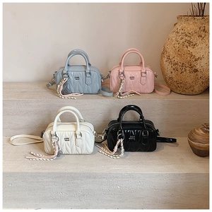 Detailed close-up of quilted Boston bags in blue, pink, white, and black with V-stitch texture