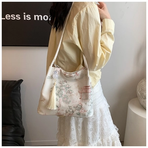 Detailed embroidery of Chinese style landscapes and tassels on a white tote bag