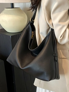 Minimalist black lychee leather large tote bag with adjustable shoulder strap and gold hardware