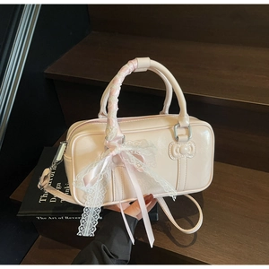 Macro detail of soft pink bowling bag with lace ribbons and silk bow on wooden steps