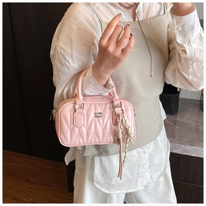 Detail of pink quilted hobo bag with GQH logo and striped silk scarf accessory