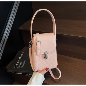 Detail of light pink crossbody phone bag featuring leather stitching and woven texture