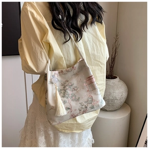 Detail of elegant Chinese style embroidery and tassel on off-white tote bag for women