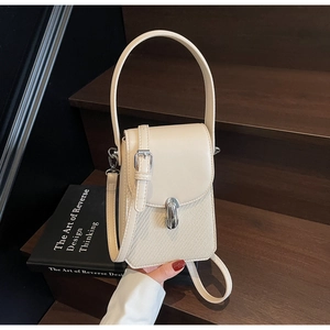 Close-up of beige crossbody phone bag with woven pattern and metal buckle on stairs