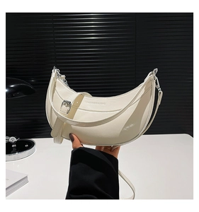 Détail du sac lune blanc avec texture en cuir brillant et texte de mode embossé