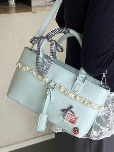 Chic light blue tote bag with lace trim and bow handle shown on a fashion model