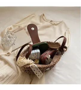 Detail der hohl gewebten Strohtasche mit brauner Lederklappe und innerem Stauraum