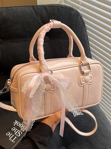 Pink ballet-style bow handbag with lace-wrapped handles and crossbody strap