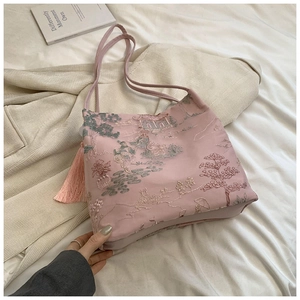 Détail du sac en satin rose avec broderie de paysage chinois et pompon élégant