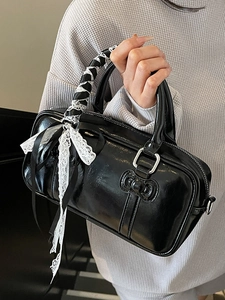 Glossy black bowling handbag with decorative lace ribbons and stylish bow accents