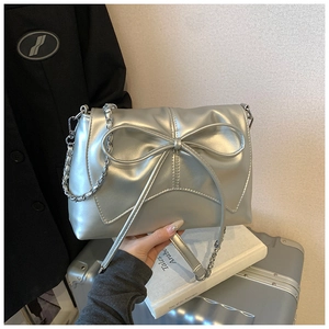 Close-up of metallic silver ballet bow handbag with chic chain strap and pleated details