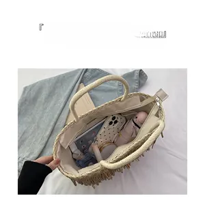 Vue détaillée du sac cabas en paille montrant la grande capacité pour iPad et accessoires
